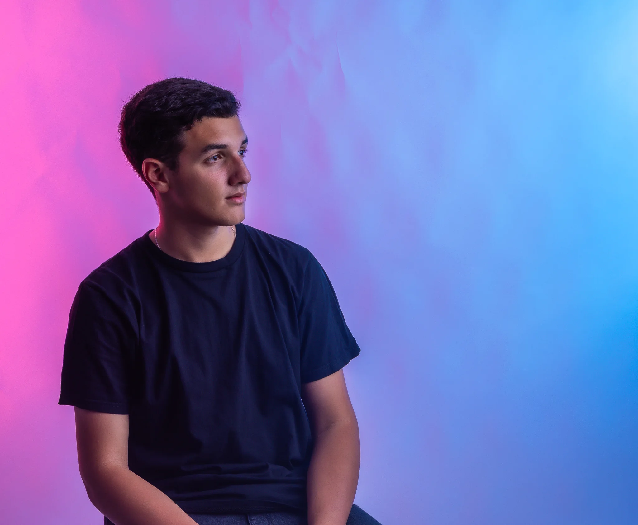 Vinicius em um retrato de estúdio com iluminação rosa e azul